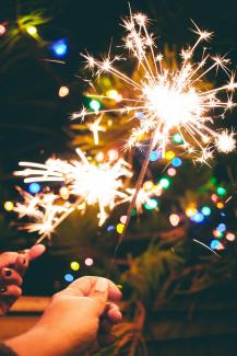 a person is holding a sparkler in their hand by Marisol Benitez courtesy of Unsplash.